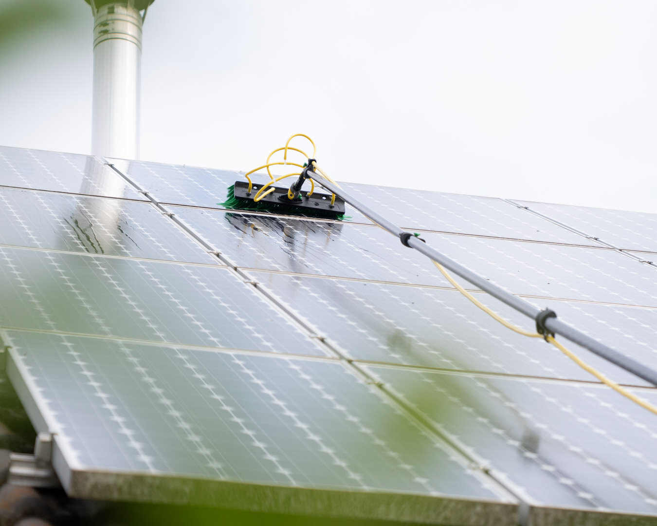 Eine Bürste reinigt die Photovoltaikanlage auf dem Dach